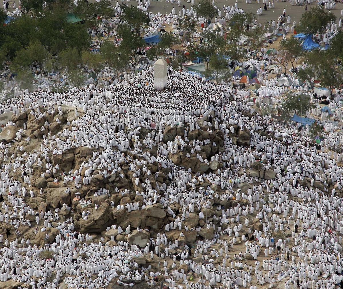 Pilgrims at Arafah with hands raised in supplication, the sun beginning to set